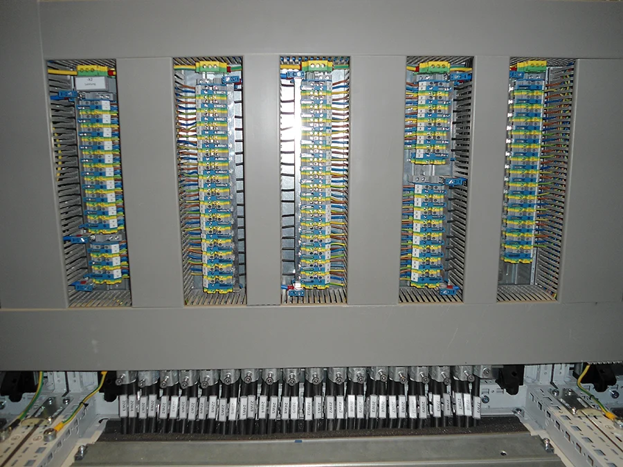 Schaltschrank mit Klemmenleisten und ordentlich verlegten Kabeln, Detailansicht einer industriellen Elektroinstallation