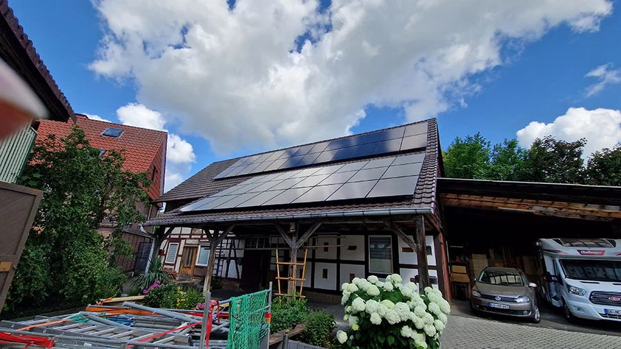 Fachwerkhaus mit Solaranlage auf dem Dach unter blauem Himmel