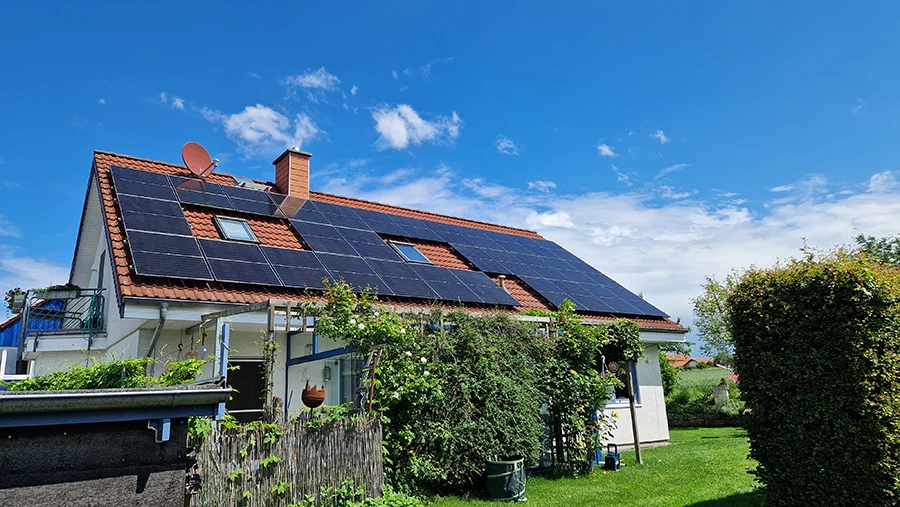 Einfamilienhaus mit Solaranlage auf dem Dach unter blauem Himmel